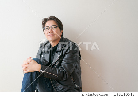一位五十多歲、戴著眼鏡、穿著皮夾克的男子 一位五十多歲、戴著眼鏡、穿著皮夾克的男子 135110513