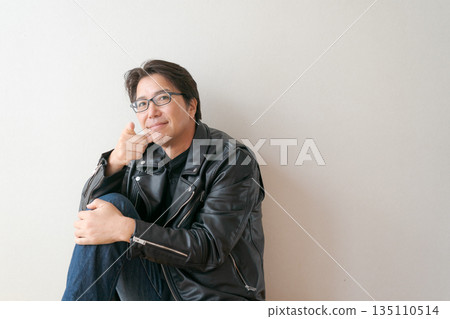 一名五十多歲、身穿皮夾克的男子指著前方。 135110514