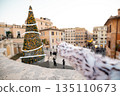 Woman pointing at festive Christmas tree near the Spanish Steps in Rome 135110673