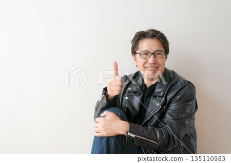 A man in his 50s wearing a leather jacket A man in his 50s wearing a leather jacket 135110983