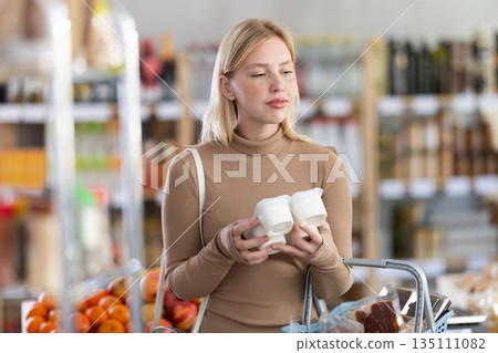 Young woman choosing yogurt in grocery store 135111082