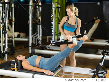 trainer helps the client work with the muscles trainer helps the client work with the muscles 135111083