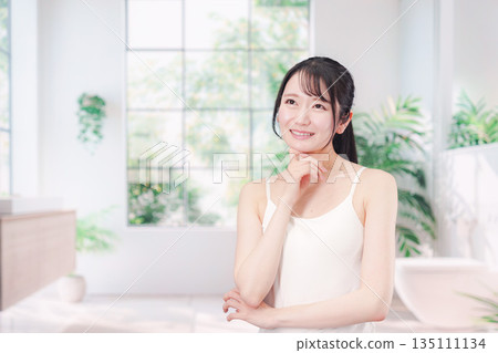 Young woman applying cream to her arms Young woman applying cream to her arms 135111134