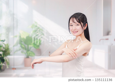 年輕女子在她的手臂上塗奶油 135111136