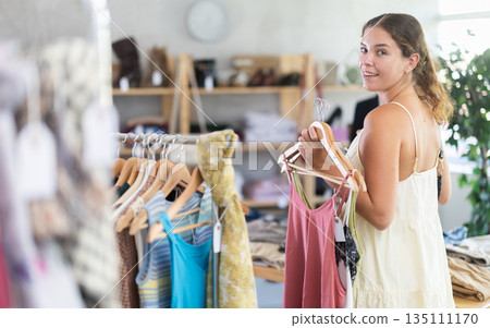 Fashionista girl near showcase examine goods, buying something clothing for summer. 135111170