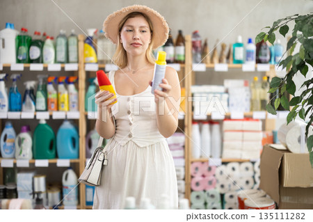 Young woman choosing insect repellents in household store 135111282