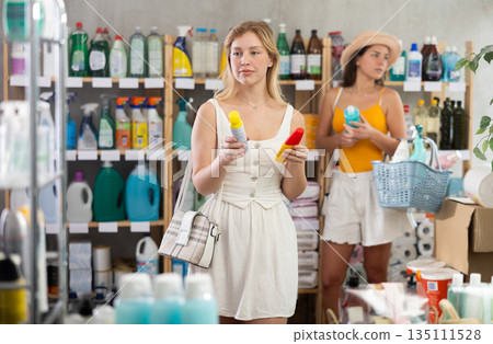 Young girl choosing repellent while other choosing something in background Young girl choosing repellent while other choosing something in background 135111528
