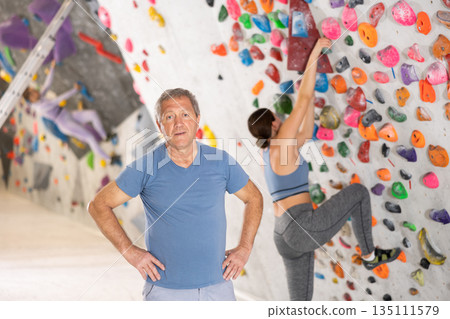 Positive senior coach man on the background of climbing wall 135111579