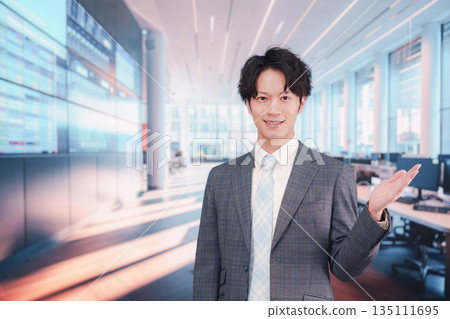 一位身著西裝的商人站在股票市場公告牌前。 135111695