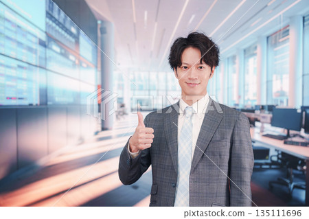 一位身著西裝的商人站在股票市場公告牌前。 135111696