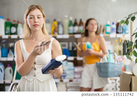 Young woman scanning qr code for cleaning spray Young woman scanning qr code for cleaning spray 135111742