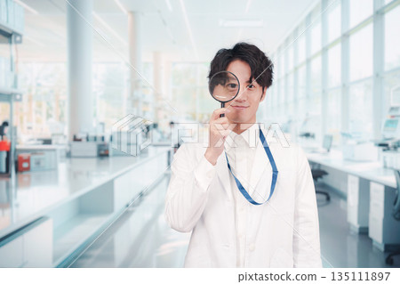 一個身穿白大褂的男人拿著放大鏡 一個身穿白大褂的男人拿著放大鏡 135111897