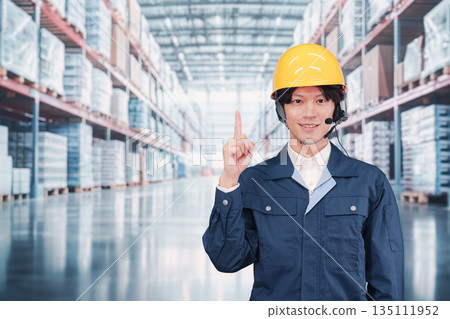 A male employee wearing a headset operating a warehouse A male employee wearing a headset operating a warehouse 135111952