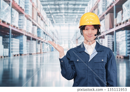 A male employee wearing a headset operating a warehouse A male employee wearing a headset operating a warehouse 135111953