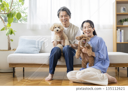 一對五十多歲的夫婦面帶笑容地看著鏡頭，他們的寵物狗也在其中——展現了與狗相伴的生活。 135112621