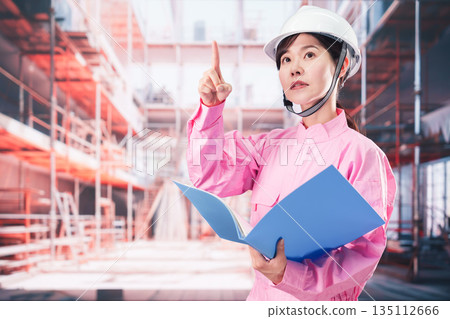 A female worker checking at a construction site A female worker checking at a construction site 135112666