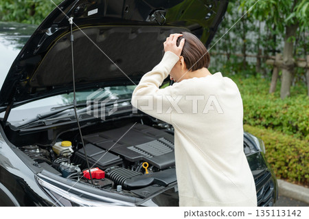 A woman suffering from car breakdown A woman suffering from car breakdown 135113142