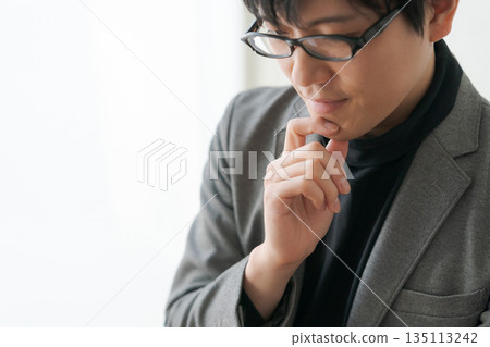 一個戴眼鏡的男人在思考 135113242