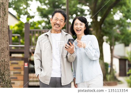 A middle-aged couple doing research on a smartphone Lifestyle image A middle-aged couple doing research on a smartphone Lifestyle image 135113354