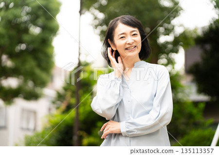 Middle-aged woman standing outside Lifestyle image Middle-aged woman standing outside Lifestyle image 135113357