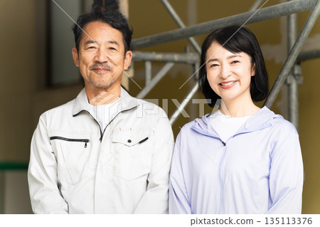 Middle-aged man and woman posing in front of a truck Construction image Middle-aged man and woman posing in front of a truck Construction image 135113376