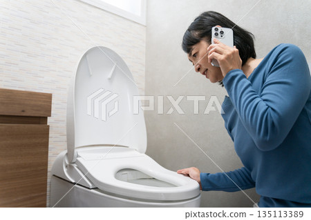 Middle-aged woman having trouble with toilet trouble Lifestyle image 135113389
