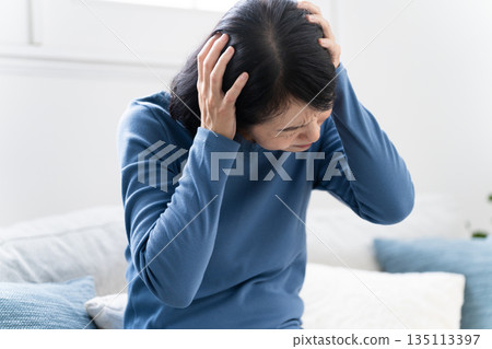 坐在沙發上的中年婦女,生活方式形象 坐在沙發上的中年婦女,生活方式形象 135113397