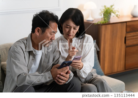A middle-aged couple doing research on a smartphone Lifestyle image A middle-aged couple doing research on a smartphone Lifestyle image 135113444