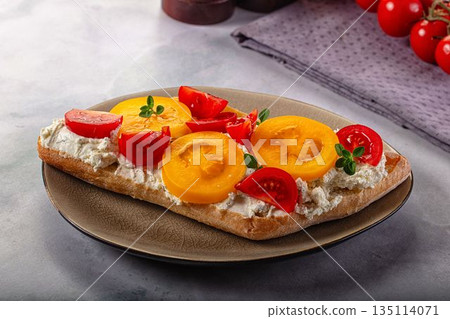 Bread with cream cheese and tomato 135114071