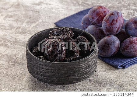 Black dry sweet prunes heap 135114344