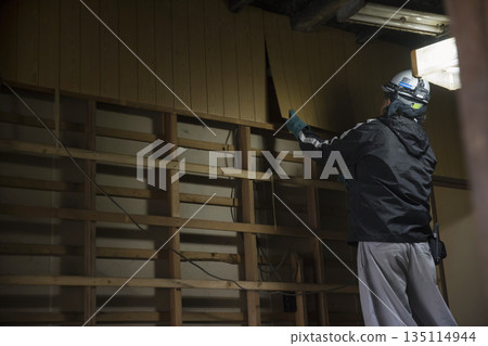 Image of old house demolition work Male worker peeling off wall 135114944