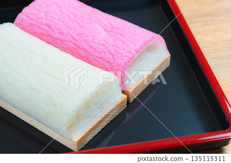 Red and white kamaboko on a black tray Red and white kamaboko on a black tray 135115311
