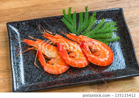 Boiled shrimp served on a black square plate 135115412