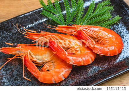 Boiled shrimp served on a black square plate 135115415