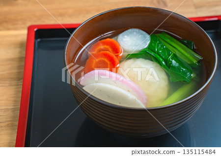 Zoni, a Japanese dish served on a black tray, is a staple of New Year's celebrations. Zoni, a Japanese dish served on a black tray, is a staple of New Year's celebrations. 135115484