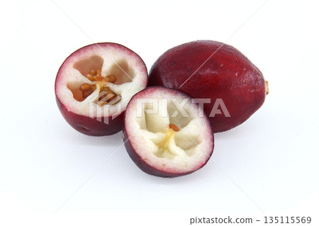 Whole and halved cranberries showing their juicy interior with seeds on a clean white background Whole and halved cranberries showing their juicy interior with seeds on a clean white background 135115569