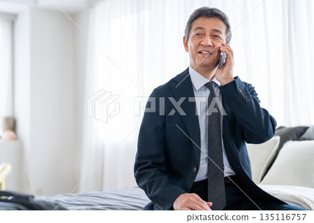 Senior man talking on smartphone from business trip Senior man talking on smartphone from business trip 135116757