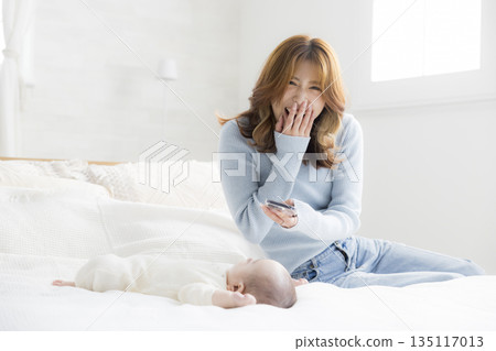 A young mother taking a photo of her baby with a smartphone 135117013