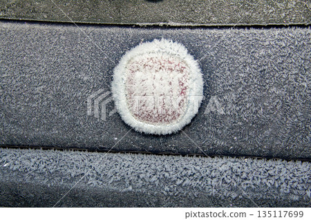 Ice frozen on the roof and window of a car Ice frozen on the roof and window of a car 135117699