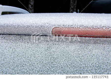 Ice frozen on the roof and window of a car 135117743