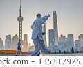 The Bund and Lujiazui area in Shanghai in the morning light, and citizens doing morning exercises. 135117925