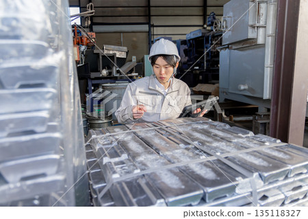 一名男工人在工廠檢查鋼錠。 135118327