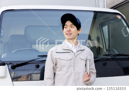 Delivery staff looking up in front of a truck Delivery staff looking up in front of a truck 135118333