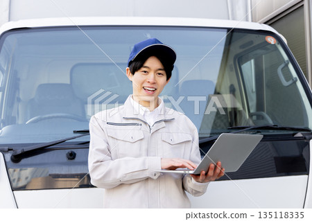 Delivery staff using laptop in truck 135118335