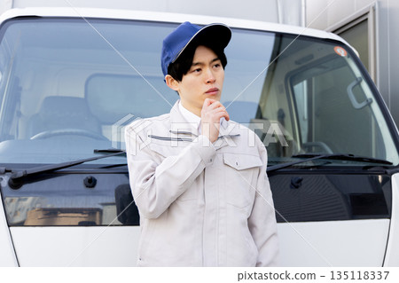 A delivery staff member worried in front of a truck A delivery staff member worried in front of a truck 135118337