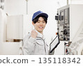 Male worker working in front of a factory control panel 135118342