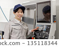 Male worker working in front of a factory control panel 135118344
