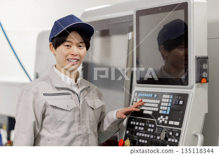 Male worker working in front of a factory control panel Male worker working in front of a factory control panel 135118344