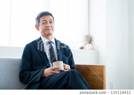 商務人士在飯店沙發上放鬆地喝咖啡 商務人士在飯店沙發上放鬆地喝咖啡 135118412