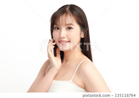 A beautiful young Asian woman with clean, fresh skin against a white background. Skincare, facial treatment, cosmetology, beauty, and spa. An elegant portrait of an Asian woman. 135118764